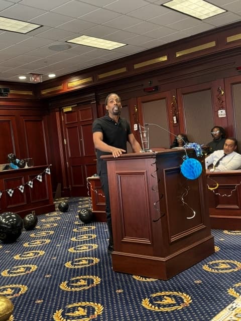 A graduate speaking from the courtroom lectern